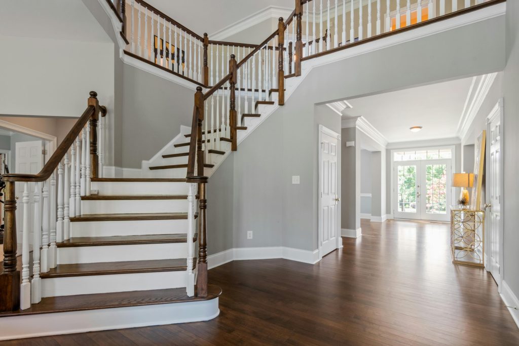 Bright and spacious entryway with wooden staircase and natural lighting.